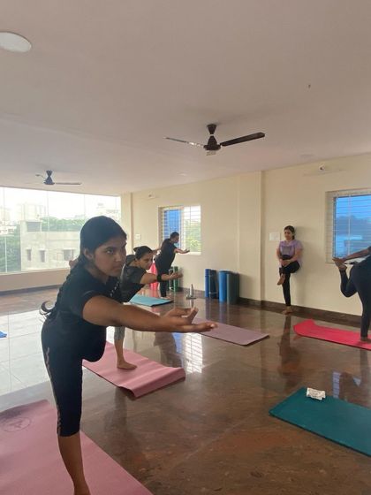 Students finding their balance in a variation of Warrior III. This pose builds strength in the ankles and legs and improves concentration.