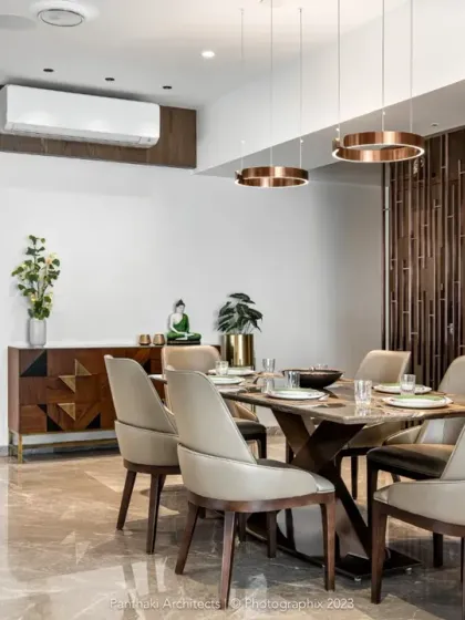 This dining space combines the sleekness of a marble floor with the warmth of wood. The geometric sideboard and circular pendant lights add a touch of modern artistry, while the overall design remains functional and inviting.