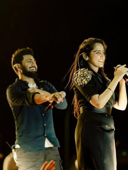 Asees Kaur and Abhishek Nailwal sharing a fun moment on stage during the concert.