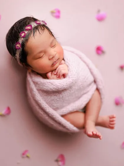 Love at first sight. This pose, with the baby curled up in a pink wrap, looks so natural and womb-like, highlighting their tiny, precious form.