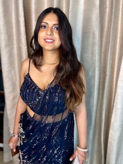 Glamour redefined. This look is modern and chic, with a subtle smokey eye and glowing skin that complements her navy blue sequin saree.