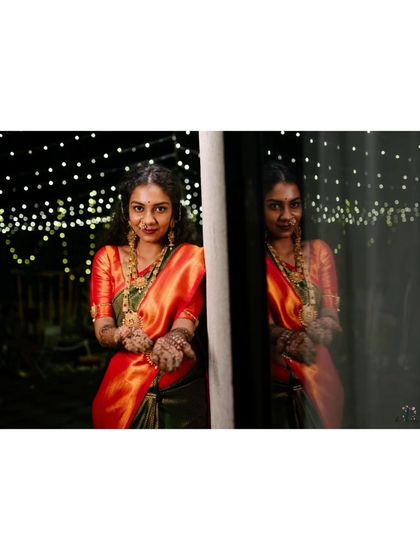 A creative portrait of the bride by a window at night, her reflection creating a moody and artistic effect.