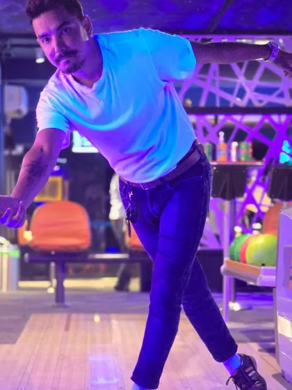 A player strikes a stylish pose after releasing the ball. Our bowling alley is not just for gaming, it's for having fun and looking good while you do it.