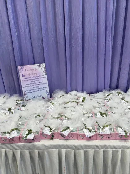 A table filled with beautifully wrapped party favors for a baby shower. Each gift is thoughtfully packaged with a small tag, ready for guests to take home as a token of appreciation.