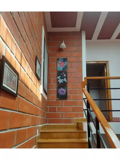 Sunlight grazes an exposed brick wall along a staircase, highlighting its texture and warmth.