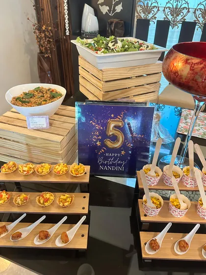 An appetizer station we set up for a 5th birthday party. The spread includes corn cups, chicken popcorn, and other kid-friendly bites alongside salads for the adults.