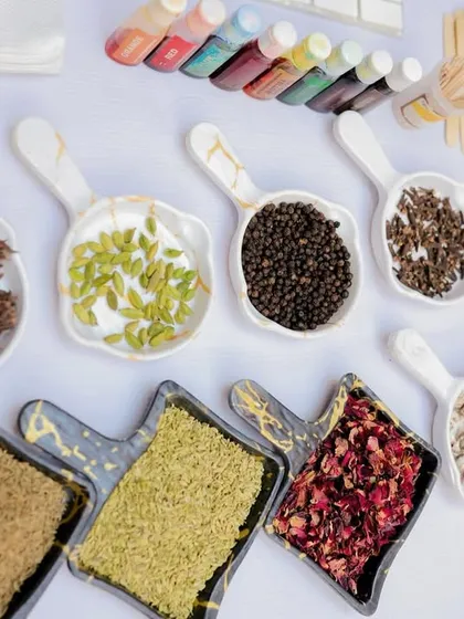 The beautiful array of ingredients for the candle-making station, including dried flowers, spices like star anise and cinnamon, and various color dyes.