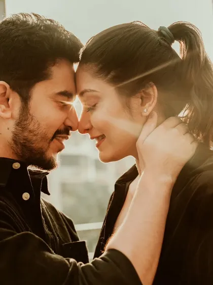 A beautiful, sunlit close-up of a couple sharing an intimate moment. The soft backlight creates a dreamy, romantic mood, perfect for a pre-wedding portrait in Mumbai.