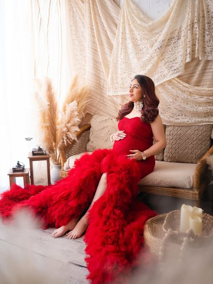 A beautiful shot in our boho setup, this mamma looks radiant in a dramatic red ruffled gown. It shows how we can mix different styles and props.