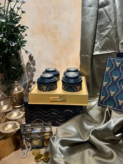 A sophisticated navy and gold themed dry fruit box with a matching bag. The intricate patterns give it a very royal and festive feel.
