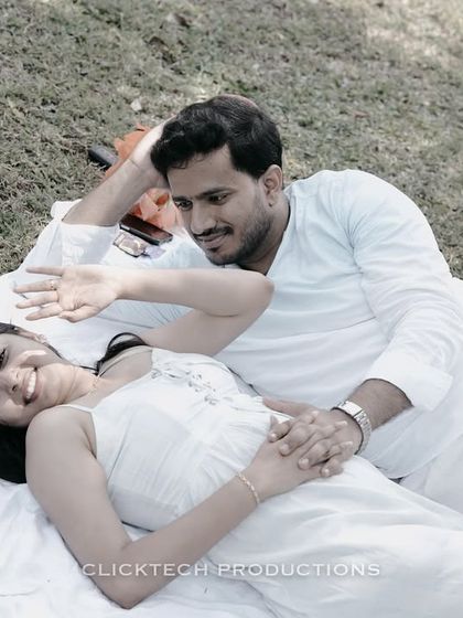 A relaxed and candid moment of a couple lying on a picnic blanket in a Coorg park, sharing a laugh.
