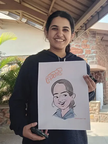 A happy guest with her caricature, complete with her name "Aditi" in a fun font.
