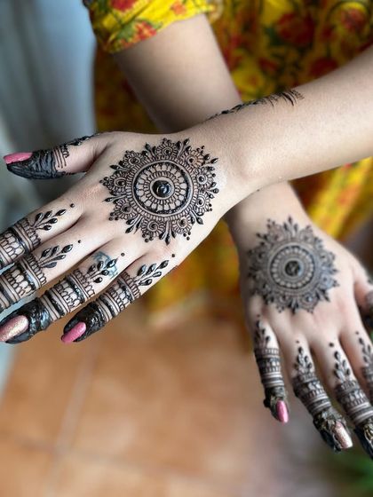 A simple and elegant mandala design for Karwa Chauth. This style focuses on a central pattern with decorated fingers, leaving some open space on the hand.