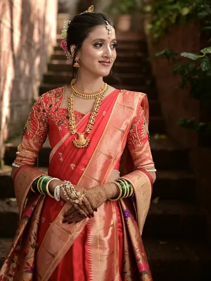 This bride is wearing a classic red Paithani saree in a Navari drape for her wedding. I focus on creating sharp, clean lines that allow the bride to move comfortably while looking absolutely stunning.