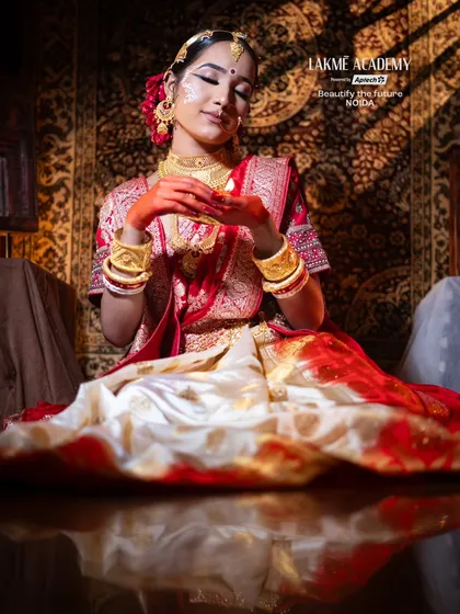 A regal Bengali bridal portrait. The rich textures of the background and saree are complemented by the warm, golden light and the bride's flawless makeup.