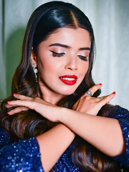 A dramatic pose highlighting the flawless skin and bold makeup choices. This look is all about confidence and high-fashion glamour.
