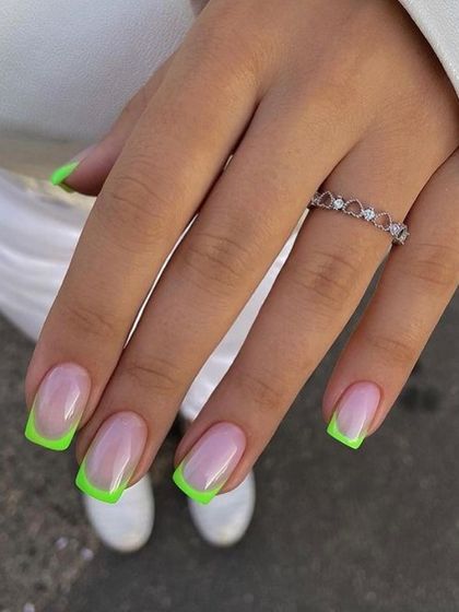 A bold and modern take on the French manicure, featuring square-shaped nails with bright, neon green tips.