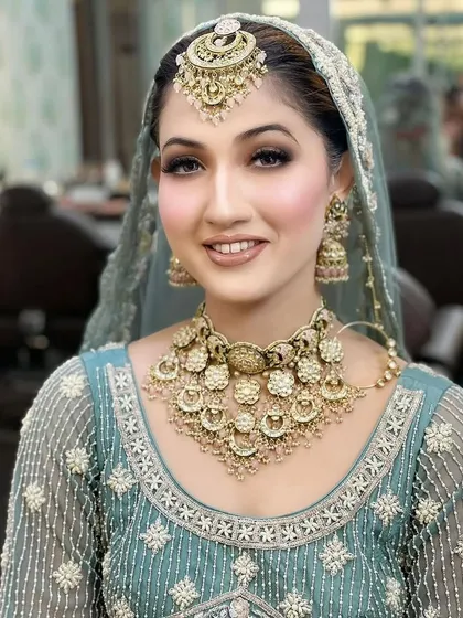 A vision in pastel blue. This modern bridal look features soft, luminous makeup with a nude lip and a classic smokey eye, proving that bridal beauty comes in every color.