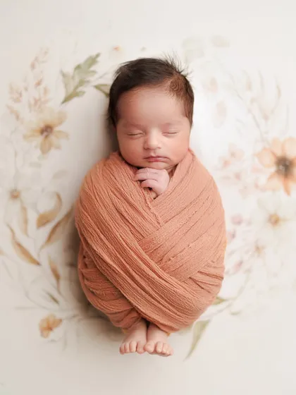 This is a photo of my own precious son, Caden, that I will cherish forever. A simple, classic wrap in warm nutmeg tones against a delicate floral backdrop is a timeless way to remember their newborn perfection.
