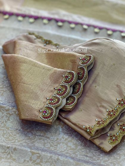 A muted gold blouse with scalloped sleeve edges, detailed with red and pink stones.