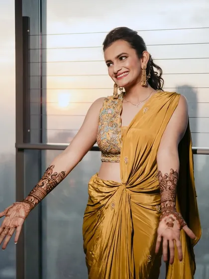 A beautiful sun-kissed shot of the bride at her Mehendi. The natural light enhances her glowing skin and the rich color of her outfit.