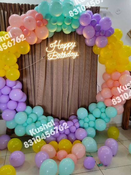 A colorful pastel balloon ring against a curtain backdrop, perfect for a cheerful home party.