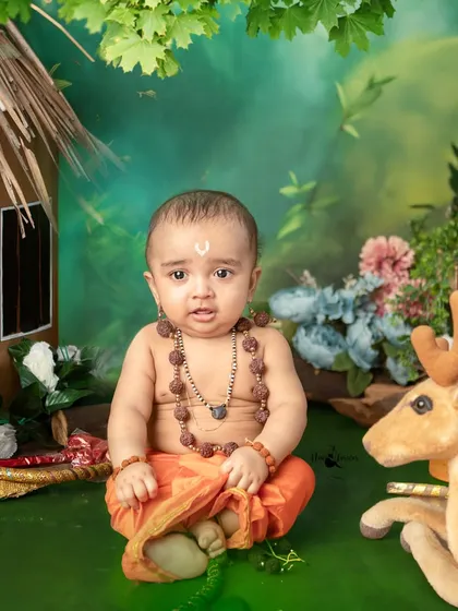 Jai Shri Ram. A little one dressed as Lord Ram sits peacefully in a forest setting, complete with a hut and a deer, bringing the epic of Ramayana to life.