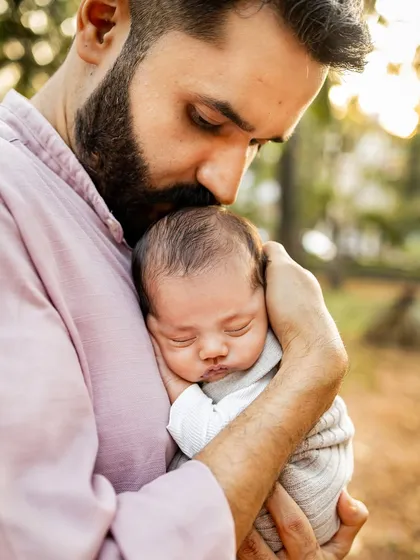 A father's gentle kiss for his newborn son during the magical golden hour. These are the fleeting, tender moments I live to capture, telling the story of your family's love.