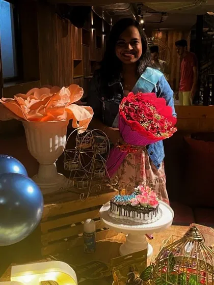 Nothing makes me happier than a smiling client. She is holding a beautiful bouquet at her birthday party, with the custom decor I arranged in the background.