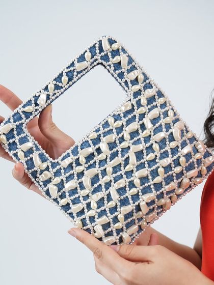 A closer look at the craftsmanship of my pearl and denim wrist bag. You can see the texture of the denim fabric against the smooth, hand-applied pearls that create a beautiful and durable design.