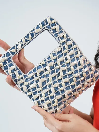 A closer look at the craftsmanship of my pearl and denim wrist bag. You can see the texture of the denim fabric against the smooth, hand-applied pearls that create a beautiful and durable design.