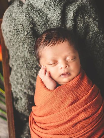 The delicate beauty of a newborn. Swaddled snugly and resting peacefully, this image captures the quiet and tender moments that pass by so quickly.
