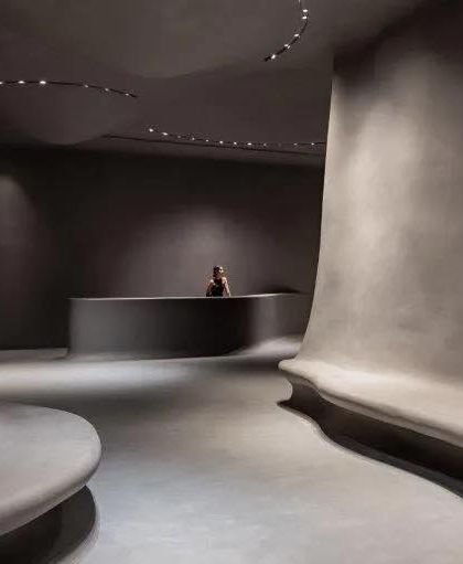 The minimalist reception area of the Aatma Manthan Museum. The curved desk and flowing walls continue the organic design language, setting a tone of introspection from the moment of entry.