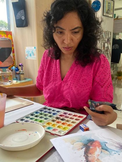 A student works on a detailed watercolor painting of koi fish. Our courses provide the time and guidance needed for intricate projects.