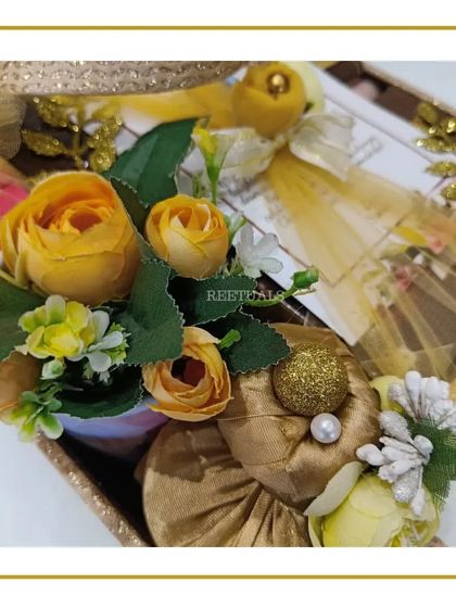 More details from the golden birthday hamper, with beautifully wrapped small gifts and floral accents.