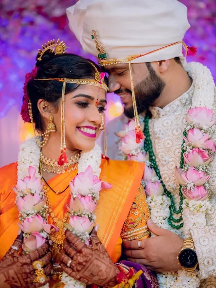 A tender moment between a Maharashtrian bride and groom, adorned with beautiful lotus varmalas. The bride's smile is absolutely infectious.