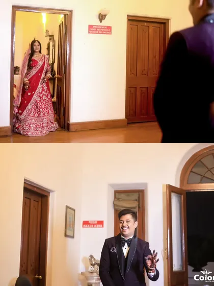 A "first look" moment, capturing the groom's happy reaction as he sees his bride in her stunning red lehenga for the first time.