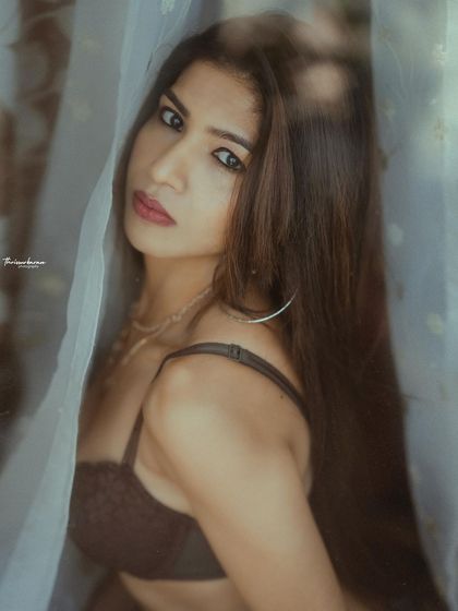 This intimate portrait, shot through a sheer curtain, has a soft and mysterious feel. The direct gaze of the model creates a powerful connection.