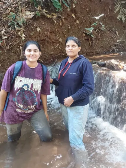 Two trekkers enjoying the cool water of a forest stream.