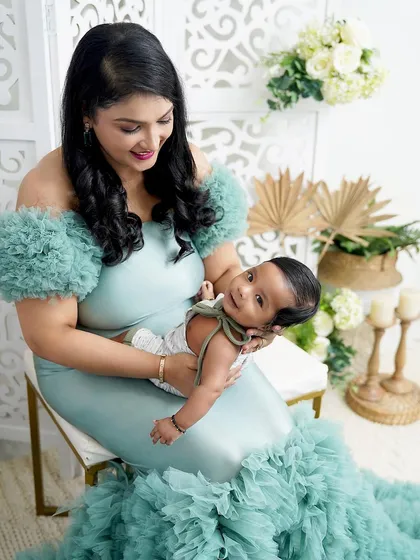 A mother's gentle touch. She cradles her newborn son, whose happy smile is a testament to the comfort and love he feels.