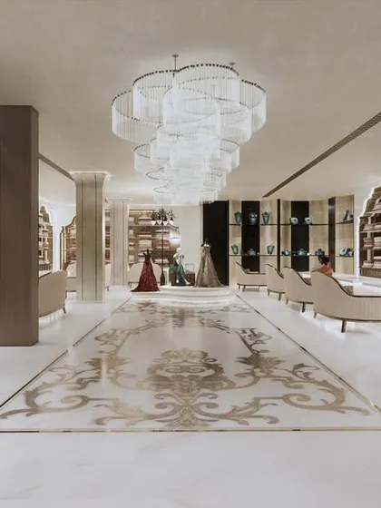 Looking down from the staircase, this view reveals the magnificent scale of the main floor. The intricate marble inlay on the floor acts as a central carpet, anchoring the space and guiding the customer's journey.