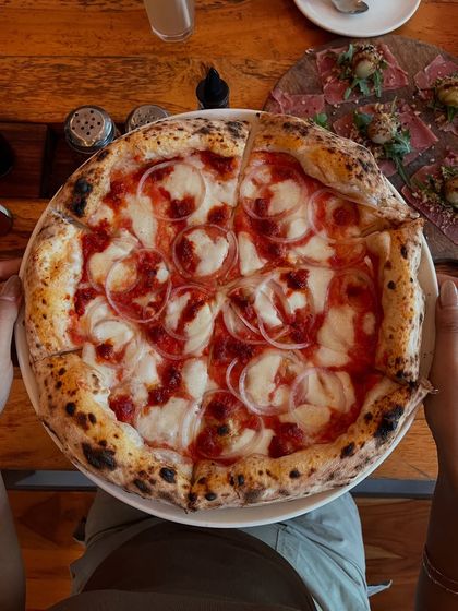 A POV shot of our Goan Sausage pizza. It's like you're right here, about to dig in.