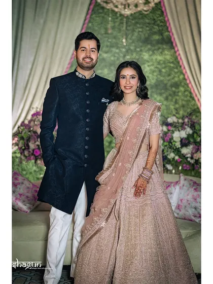 Hand in hand, hearts entwined. A classic portrait of the couple, showcasing their elegant reception outfits and the beautiful decor.
