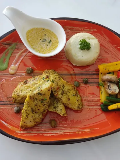 A duplicate image of our plated herb-crusted chicken meal, showcasing the consistent quality of our catering.