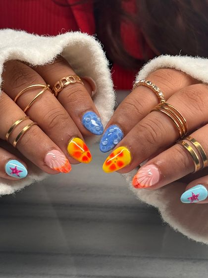 A playful, beach-themed manicure with 3D elements. This set features bubbly water textures, a sunset ombre, and sculpted seashells and starfish for a fun, vacation-ready look.