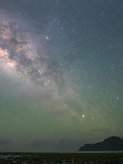 The Milky Way arching over a serene beach in the Andaman Islands. The faint green glow is airglow, a natural phenomenon that adds a magical touch to nightscape photography.