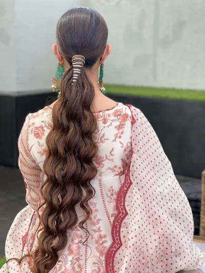A long, wavy ponytail wrapped with a diamond string for a touch of bling. This is a sophisticated and glamorous style for any evening function.
