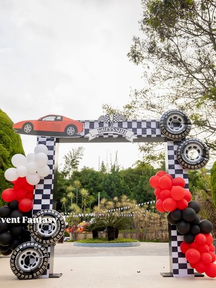 The grand entrance arch for Krianshh's Ferrari World. The arch is decorated with checkered patterns, real tires, and a sleek red sports car cutout on top.