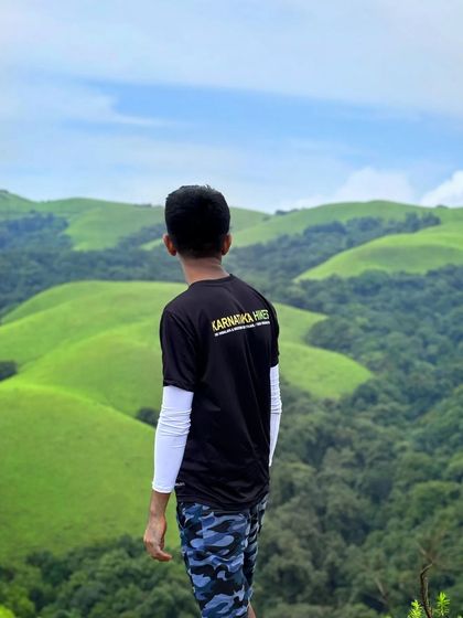 A trekker in our official t-shirt, looking out over the rolling green hills.