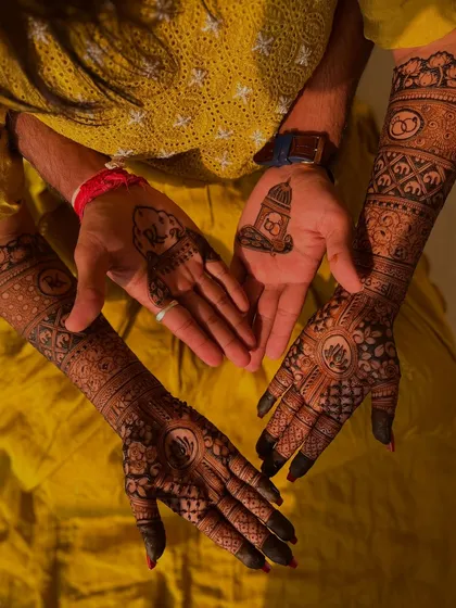 A lovely shot of the bride and groom's hands together. The bride has a full engagement mehendi, while the groom has a simple, symbolic design on his palm.